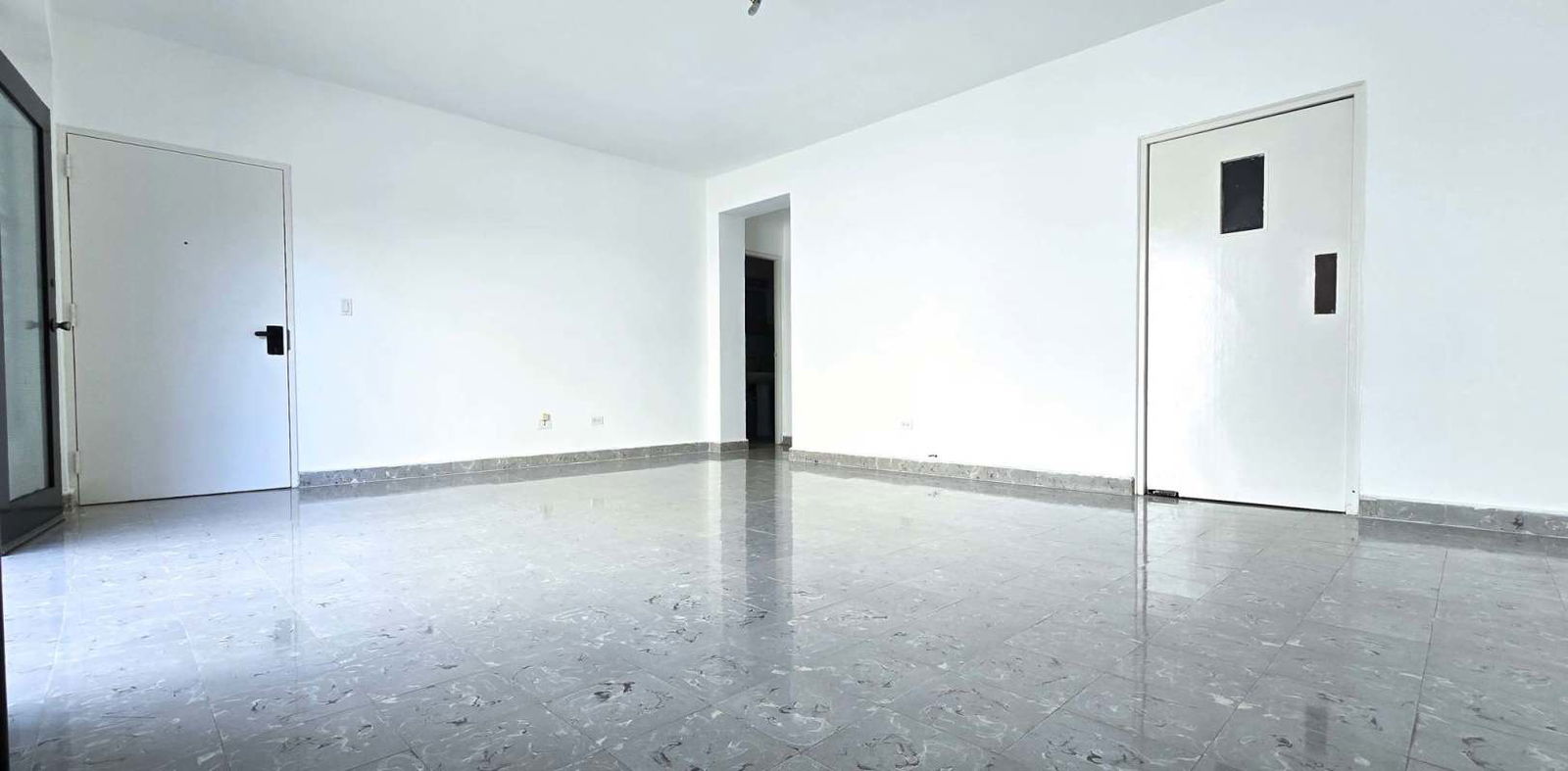 Living room with natural light, balcony view, tiled floors, and white walls in Bella Vista Panama City apartment