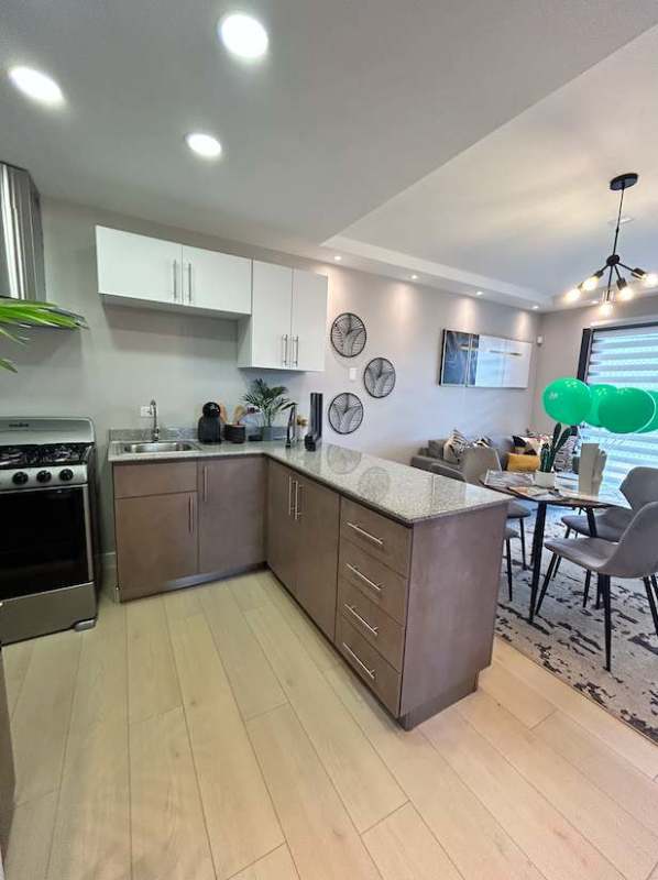 Modern open kitchen with granite countertops and dining area in Las Mañanitas apartments Panama