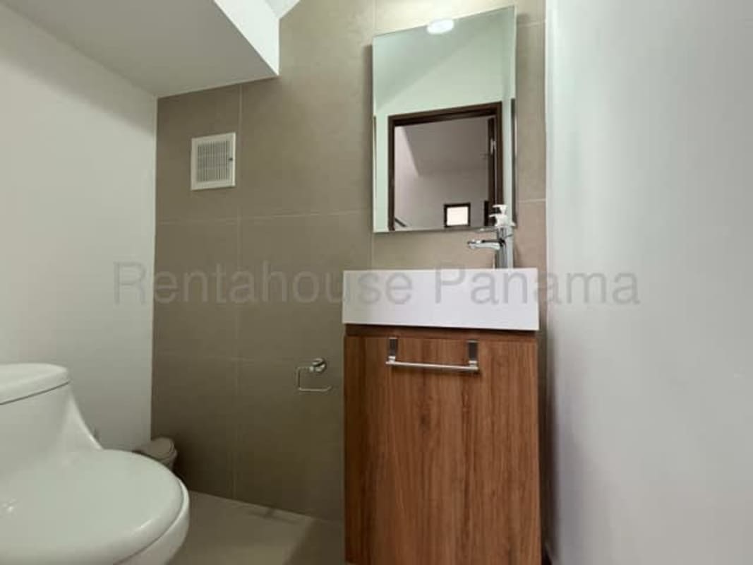 Modern bathroom with vanity mirror and elegant tile finish in house at Golf Gardens II Brisas del Golf