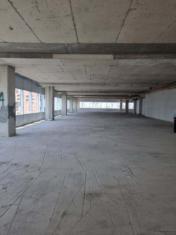 Unfinished gray shell open office space with panoramic glass windows Costa del Este