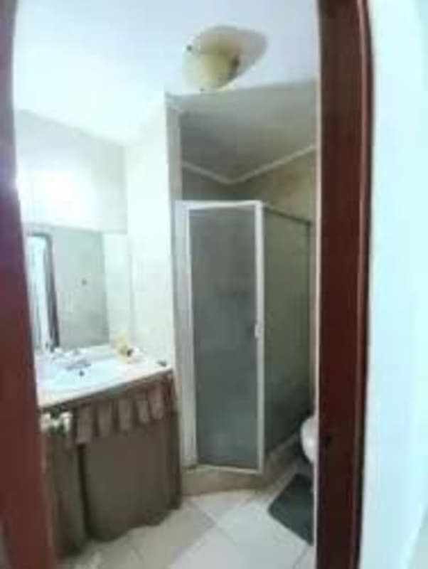 Bathroom with glass shower enclosure, tile floors, ceramic sink in Condado del Rey apartment for rent