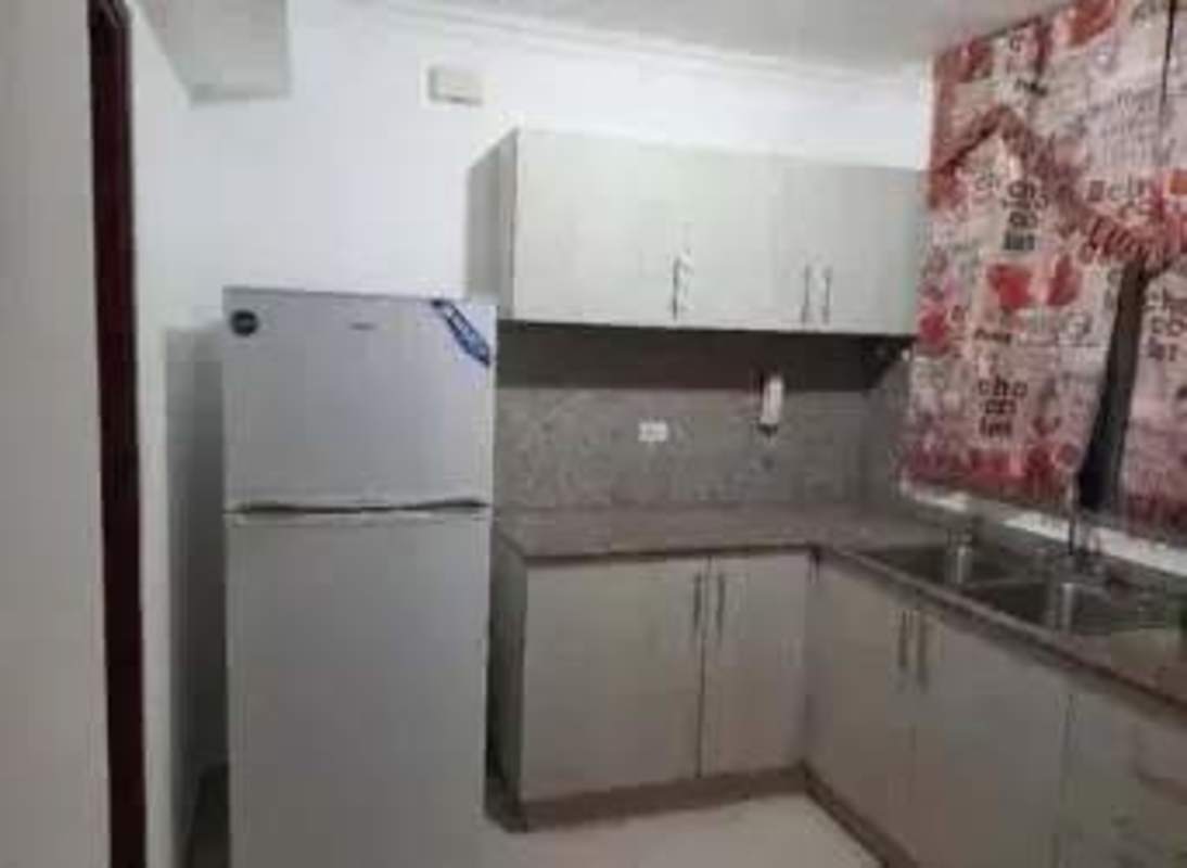 Modern kitchen with stove, fridge, granite countertop, wooden cabinets in Panama apartment for rent