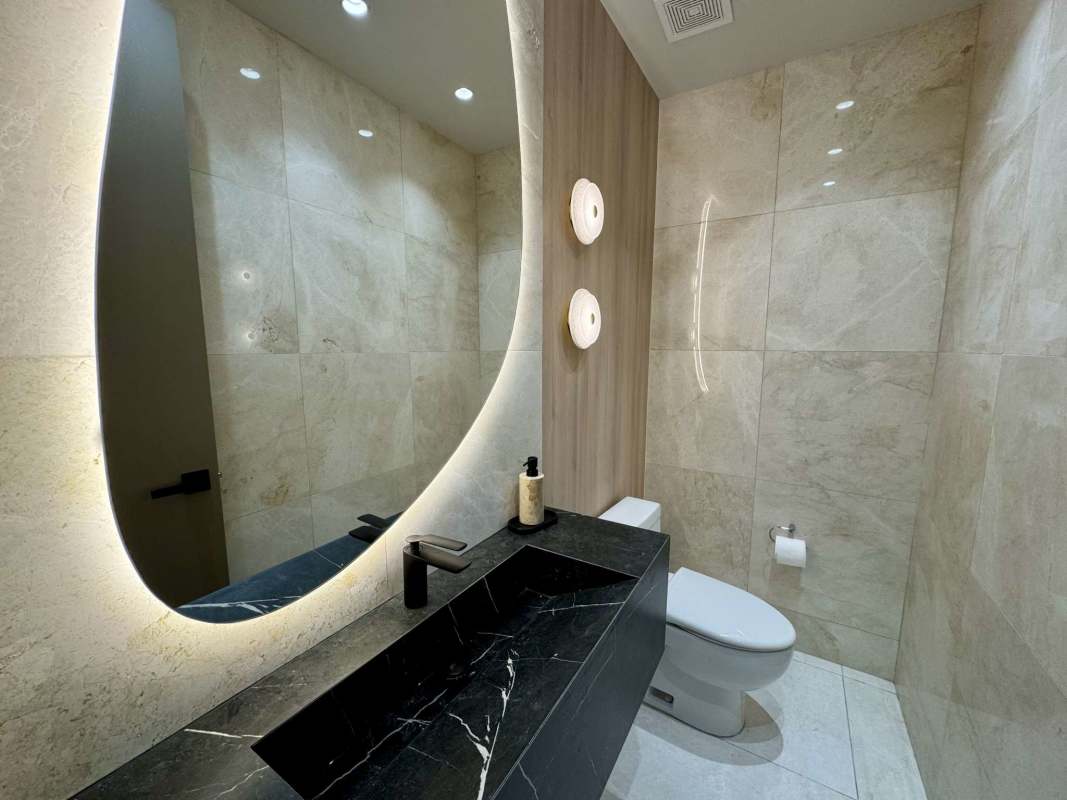 Modern bathroom featuring marble tiles, backlit mirrors and double vanity in luxury condo Punta Paitilla Panama