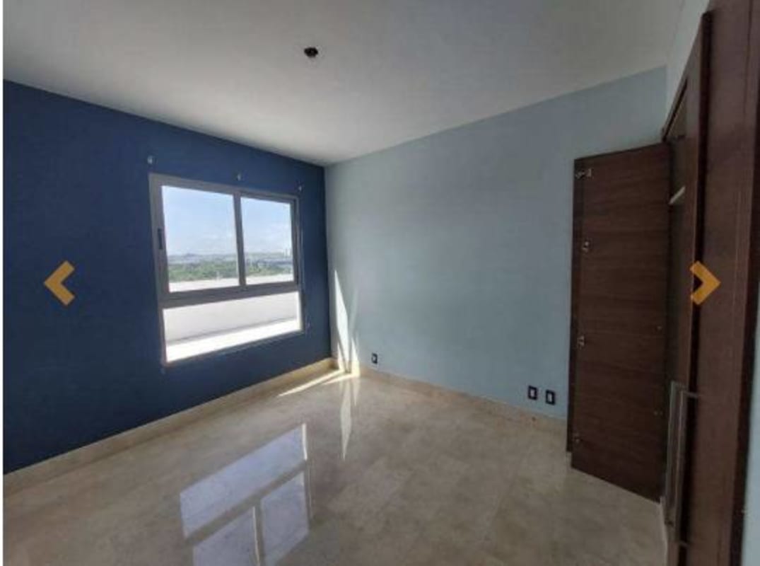 Empty bedroom with marble floor, large window, navy accent wall in PH GreenView Santa Maria Golf Panama