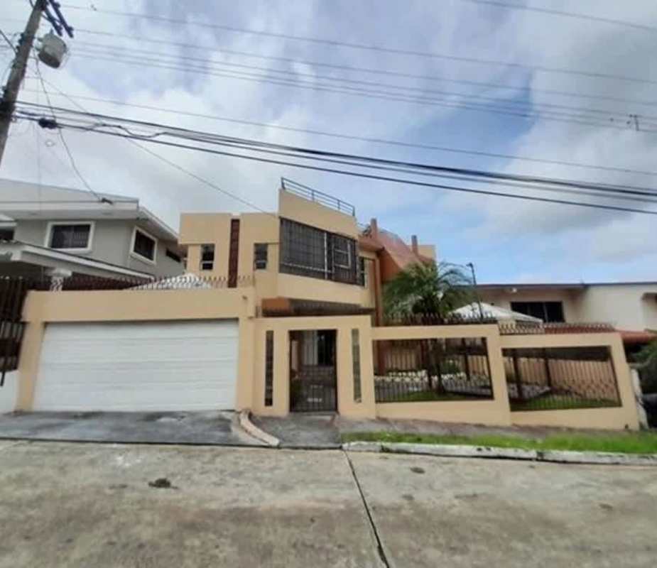 Modern two-story home exterior with large windows, electric gate, garden, garage in Villa Las Fuentes Panama