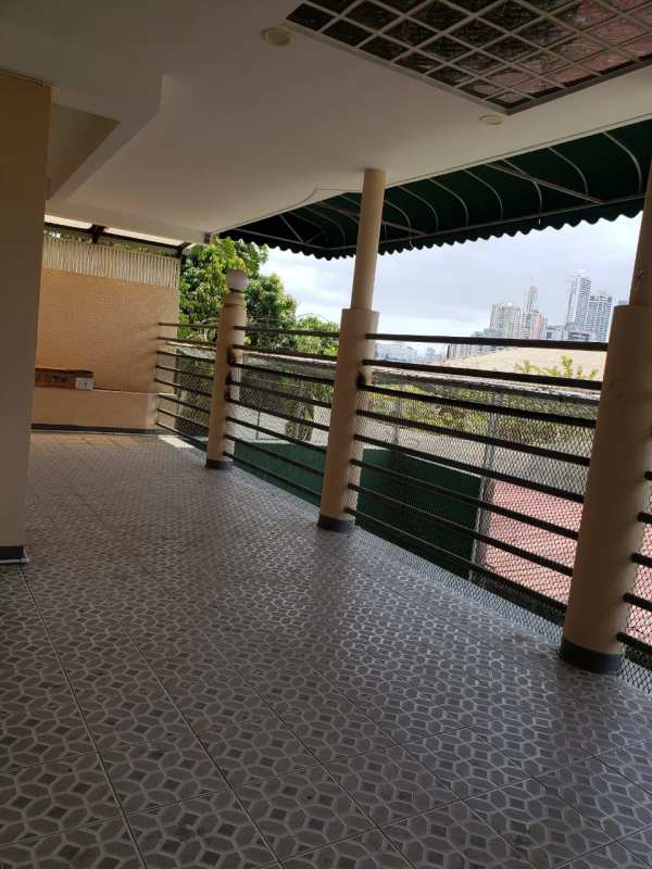Stylish bathroom with raised black tub, decorative columns, glass block window in Villa Las Fuentes Panama