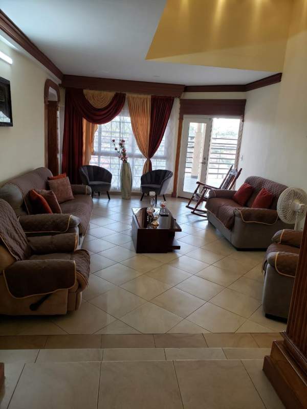 Modern bedroom featuring blue accent wall, recessed lighting, mirrored wall, and tiled floor in Villa Las Fuentes Panama