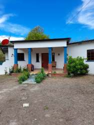 Single story house front porch blue pillars garden satellite dish for sale Nueva Gorgona Panama