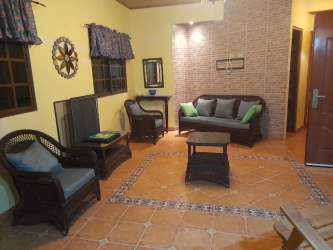 Traditional living room with wicker furniture tiled floors exposed brick affordable Panama house for sale