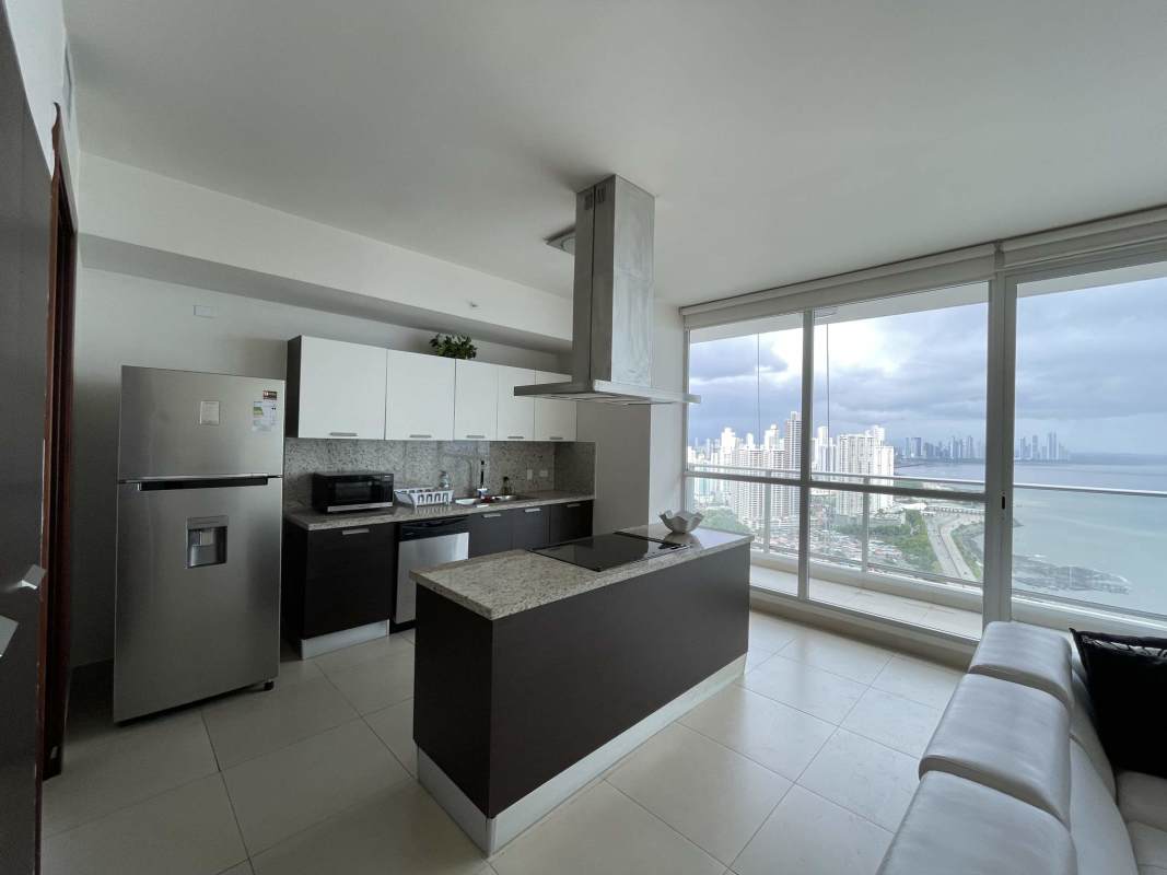 Luxury high-rise apartment living area with large balcony glass doors ocean skyline view Punta Pacifica Panama