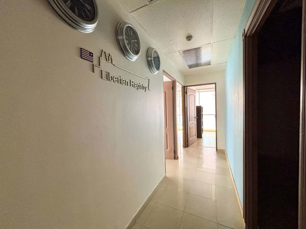 Hallway in commercial office tower with clocks directional signs modern tile City Center Tower Panama