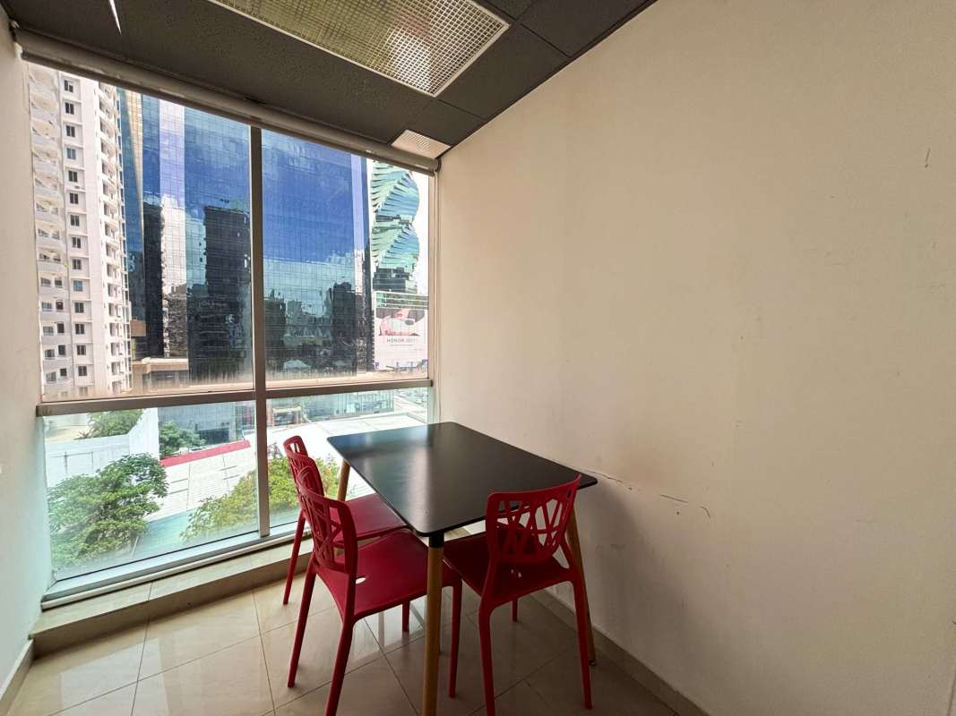Small meeting or dining corner with red chairs and city skyline window view in City Center Tower Panama