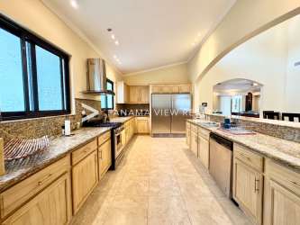 Modern kitchen with granite island, wood cabinetry, stainless appliances in Buenaventura villa