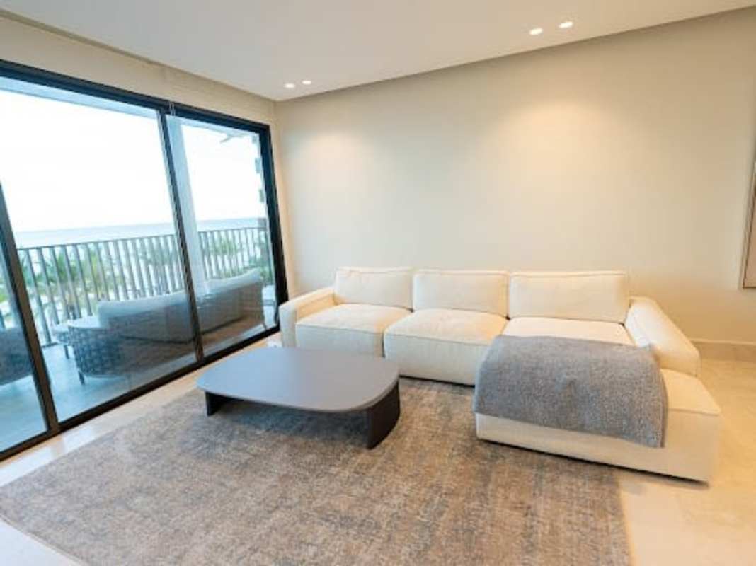 Elegant double sink bathroom with glass shower, marble finishes inside Ocean Reef Seascape Panama apartment
