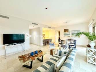 Bright open living dining condo with coastal decor, striped sofa, large windows, ocean views in Buenaventura Panama