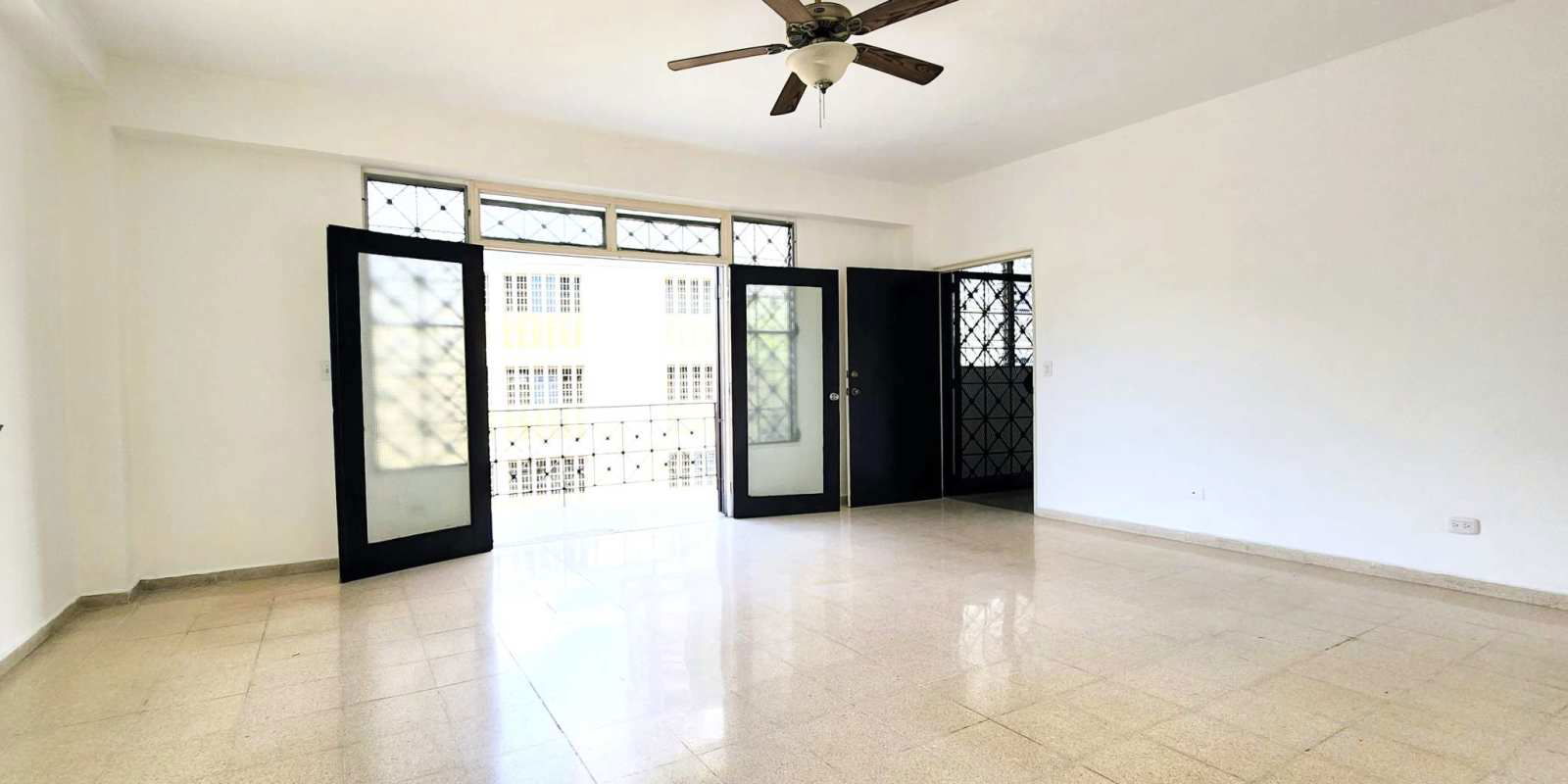 Bedroom with polished floor, built-in wood closet, window to city in Bella Vista Panama