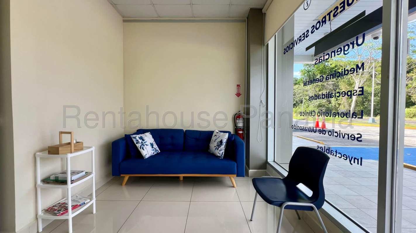 Medical clinic waiting room with blue sofa, large window and signage Clayton Panama