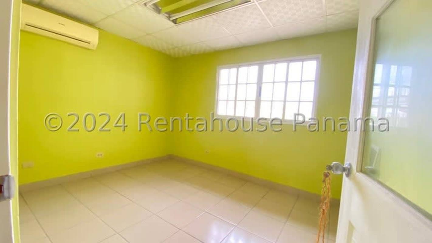 Empty bedroom with light green walls, tiled floor and AC unit Panama City