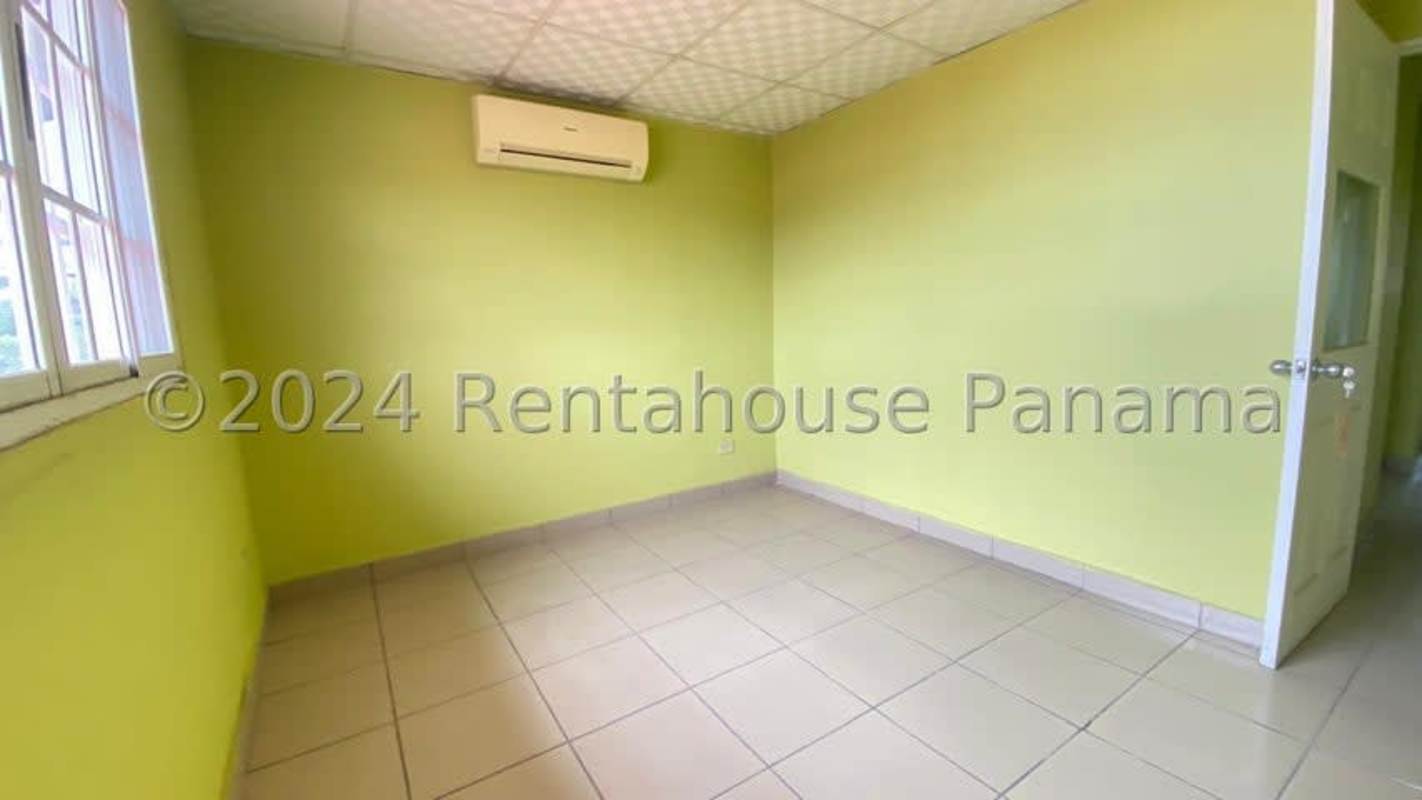 Bright empty room with lime green walls, AC, window in Panama