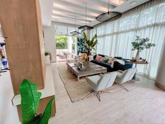 Modern kitchen open to dining area with garden pool views at PH Solea luxury apartment