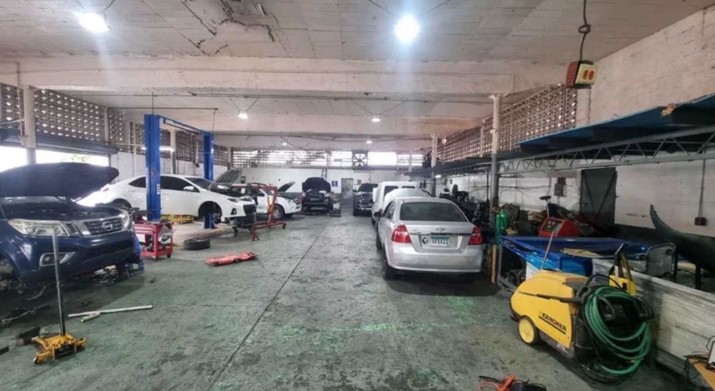 Interior of commercial auto repair workshop with hydraulic lifts and vehicles in Parque Lefevre Panama City
