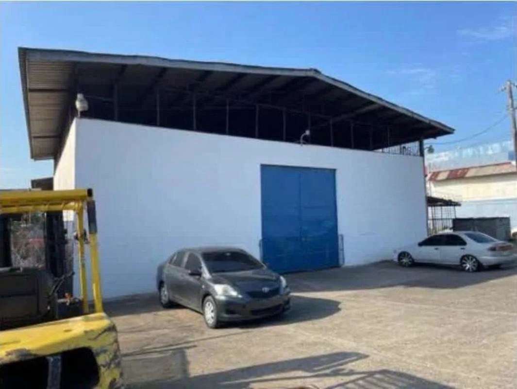 Exterior facade of industrial warehouse with blue door parking area Rio Abajo Panama
