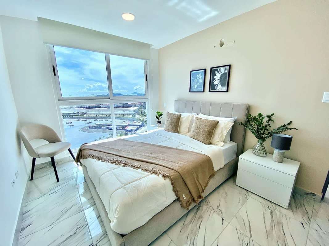 Modern bedroom with large windows waterfront views marble floors PH The Gray Panama