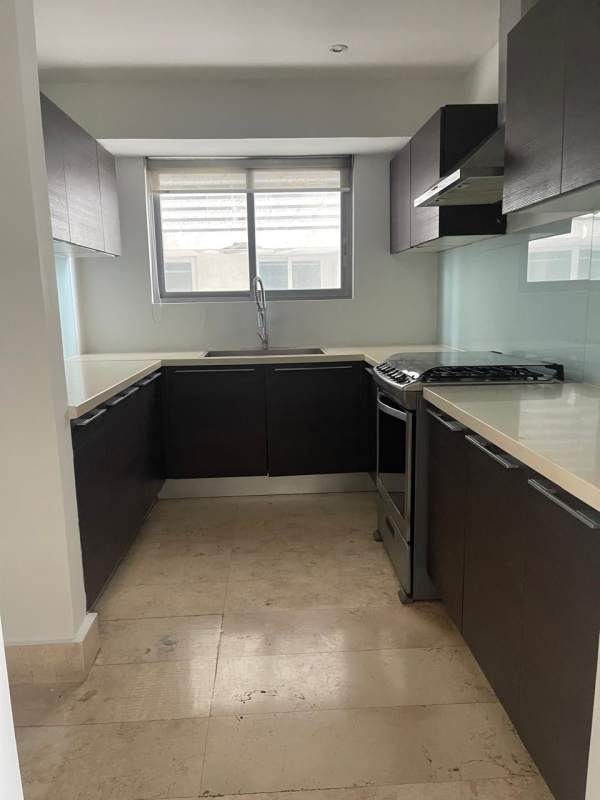 Open-concept kitchen with stone tile floors, double sink, large windows in YOO Panama apartment
