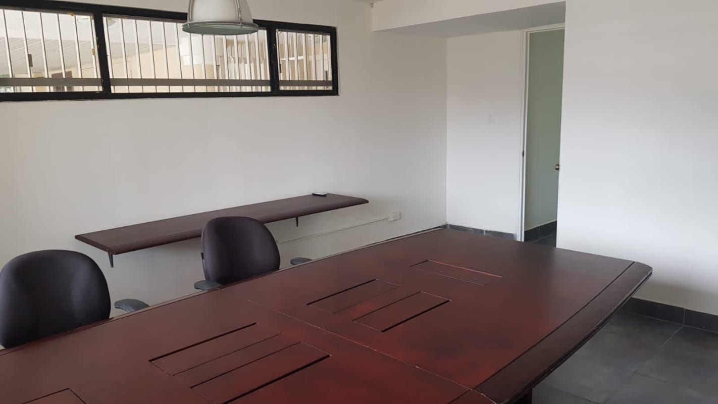 Minimalist conference space with oval table and office chairs at Villa de las Fuentes commercial property