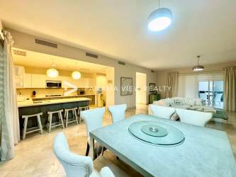 Modern open kitchen with marble floors, white cabinets, built-in appliances at Buenaventura resort