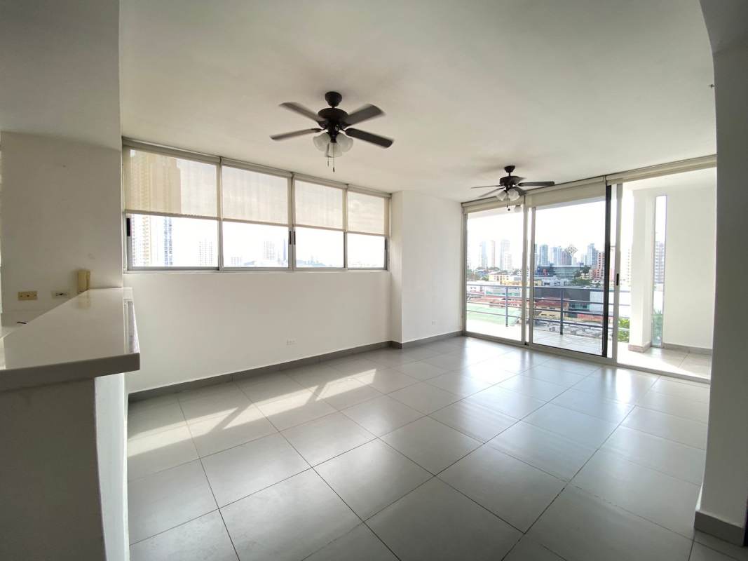 Spacious living-dining area with large window, balcony access, and ceiling fans in PH Trio Panama City