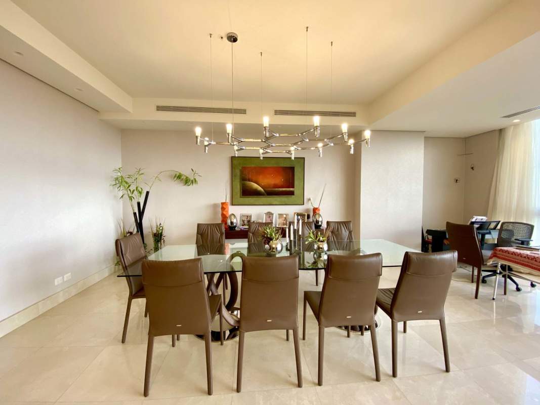 Spacious living and dining room with golf and city skyline views in penthouse Santa María Panama