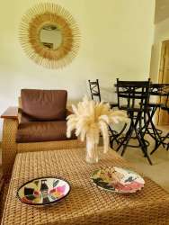 Rustic bohemian style living room with rattan coffee table and sunburst mirror in country house David Panama