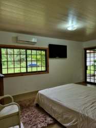 Bedroom with wooden furniture, AC, and natural light in country estate David Panama