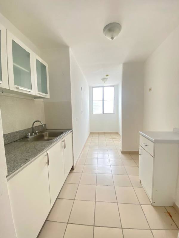 Bright galley kitchen white cabinetry granite counter window PH Carrasquilla Place rental Panama City