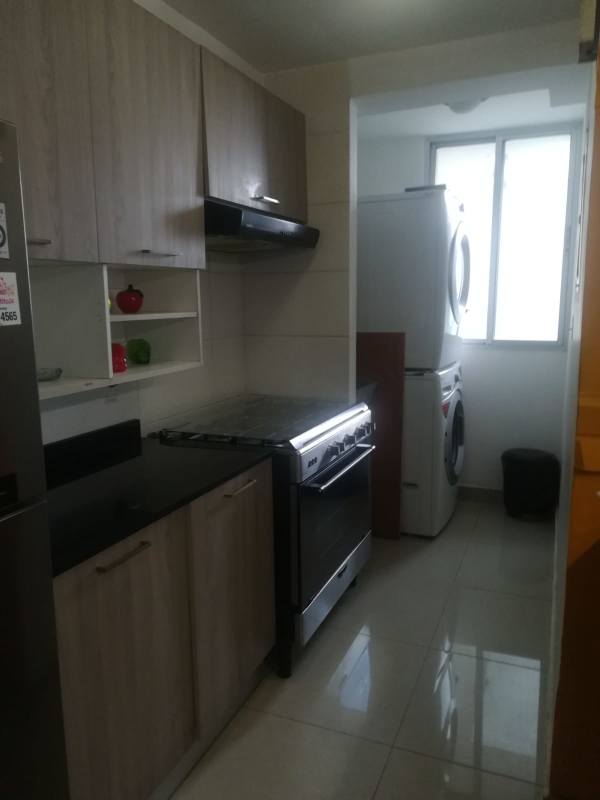 Modern kitchen with black granite, wooden cabinets, appliances in PH Coral Tower