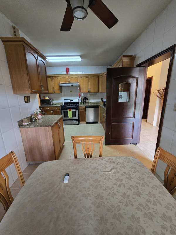 Wood cabinetry granite counter kitchen with dining space Palmeras Costa del Este Panama