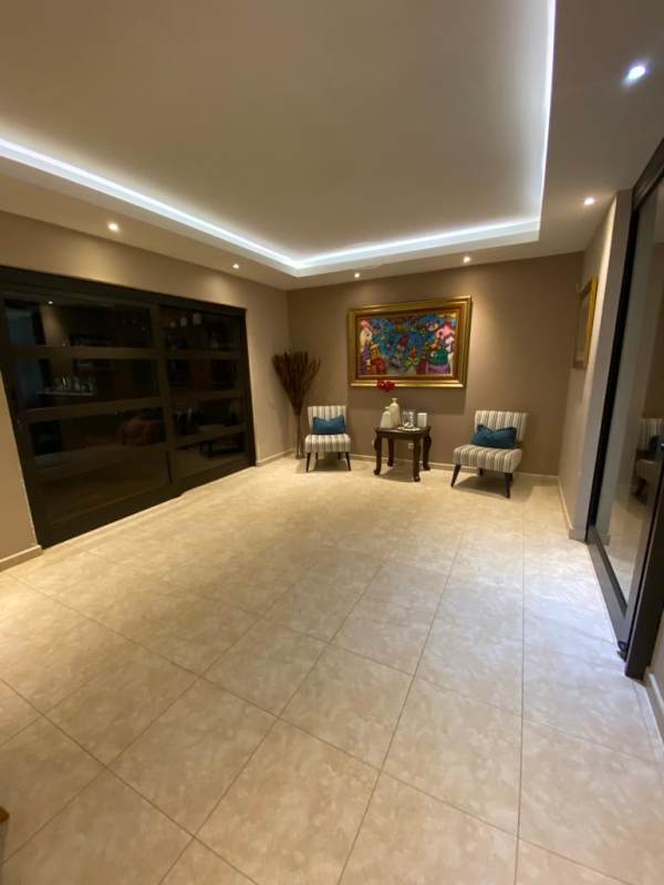 Bright contemporary foyer with accent chairs artwork Palmeras Costa del Este duplex house Panama
