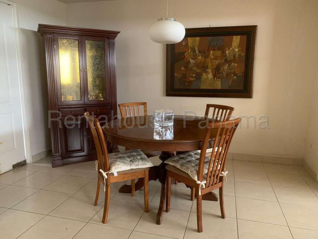 Dining room with round wooden table, pendant light, artwork, and china cabinet Dorado Springs Panama