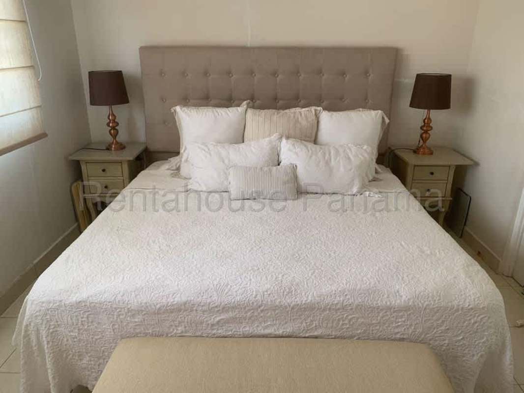 Bedroom with tufted headboard, bedside tables and lamps in Panama City