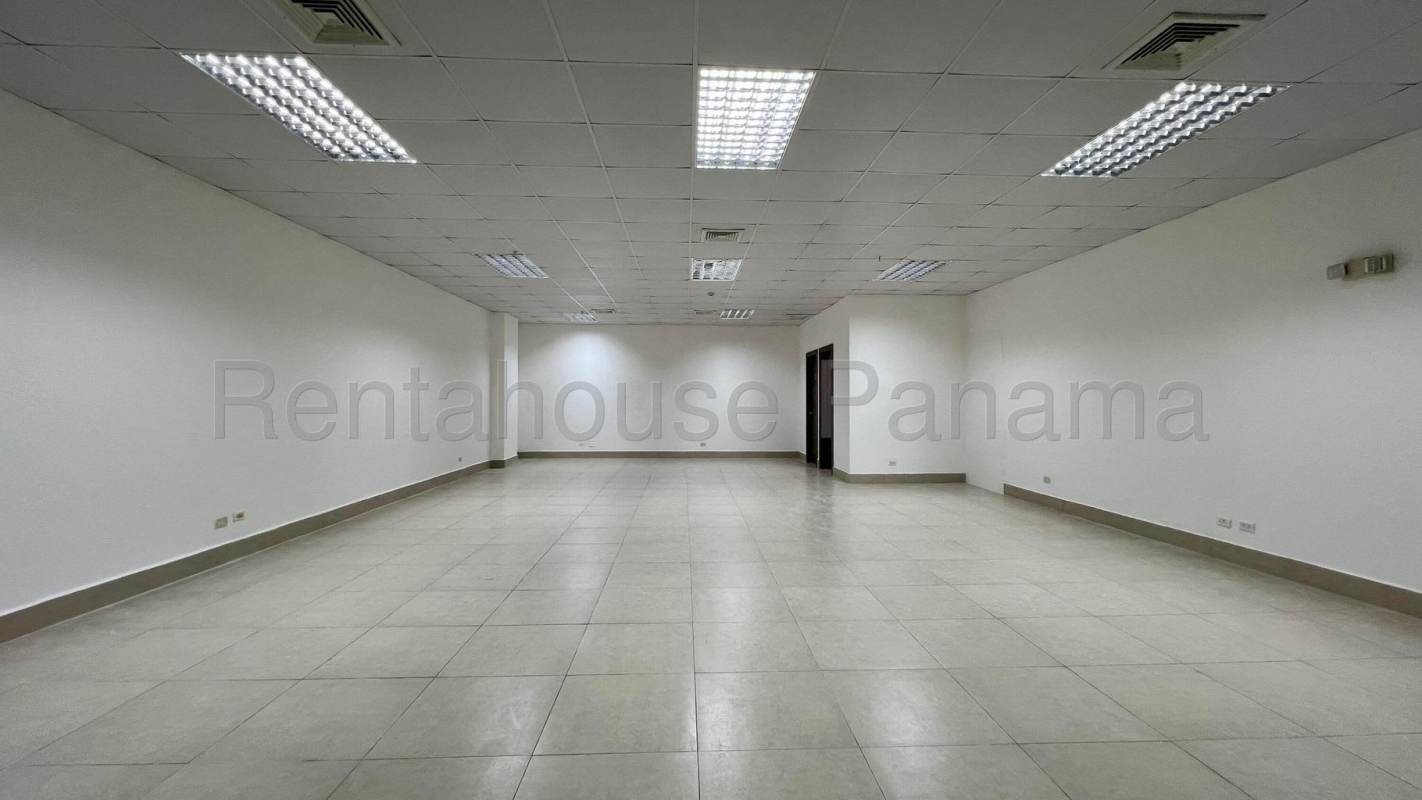 Modern commercial building exterior with glass facade and parking spaces in Albrook Panama