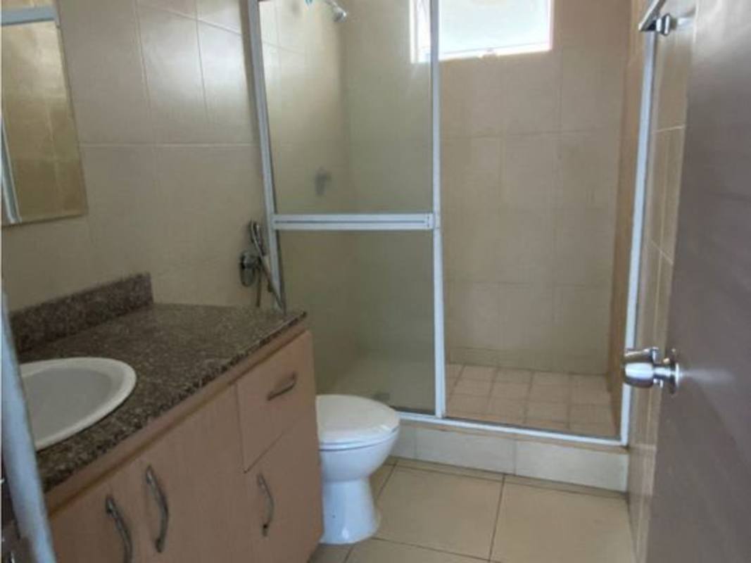 Bathroom with beige tiles, walk-in glass shower, granite countertop in Bella Vista Panama apartment