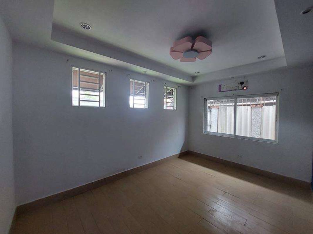 Spacious living dining area with large windows, dark ceramic tile and coffered ceiling at Rio Abajo Panama