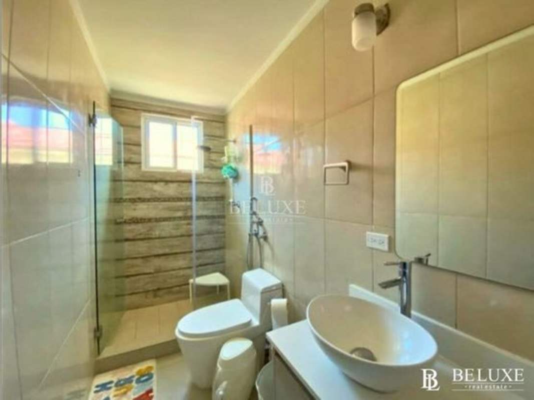 Contemporary kitchen with breakfast bar adjoining dining area in Residencial El Doral house Panama