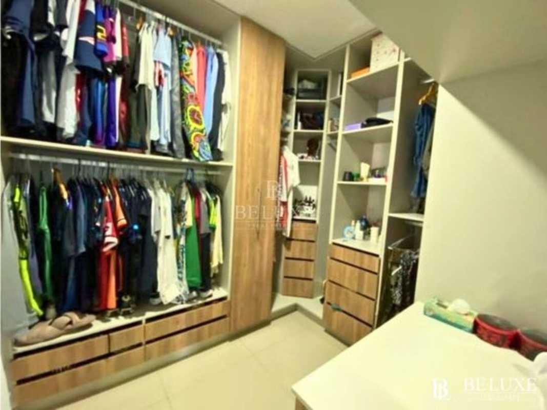 Spacious walk-in closet with vanity mirror built-in shelves and organized space in El Doral house Panama