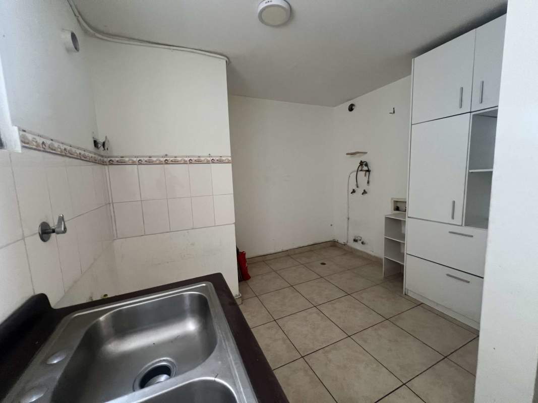 Basic kitchen with breakfast bar and cabinetry, tiled floor in PH Plaza Valencia Panama