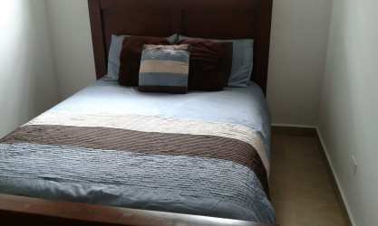 Furnished master bedroom with queen bed, striped bedding, natural light in beach house C Paradise Coronado Panama