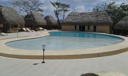 Large outdoor swimming pool with tropical palapas loungers in Coronado beach gated community C Paradise Panama