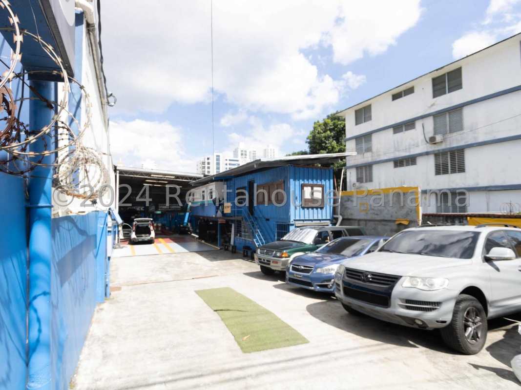 Gated industrial lot with blue container office and vehicles in San Francisco Panama
