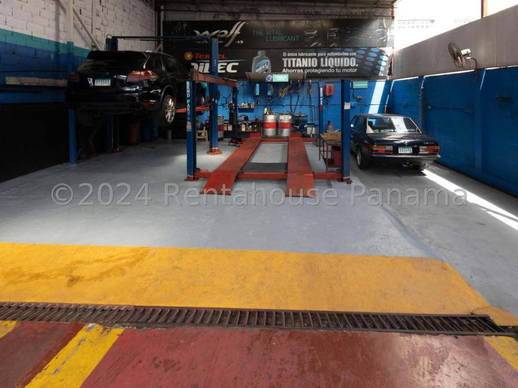 Inside mechanic garage with vehicle lift, service bays, tools and equipment in San Francisco Panama